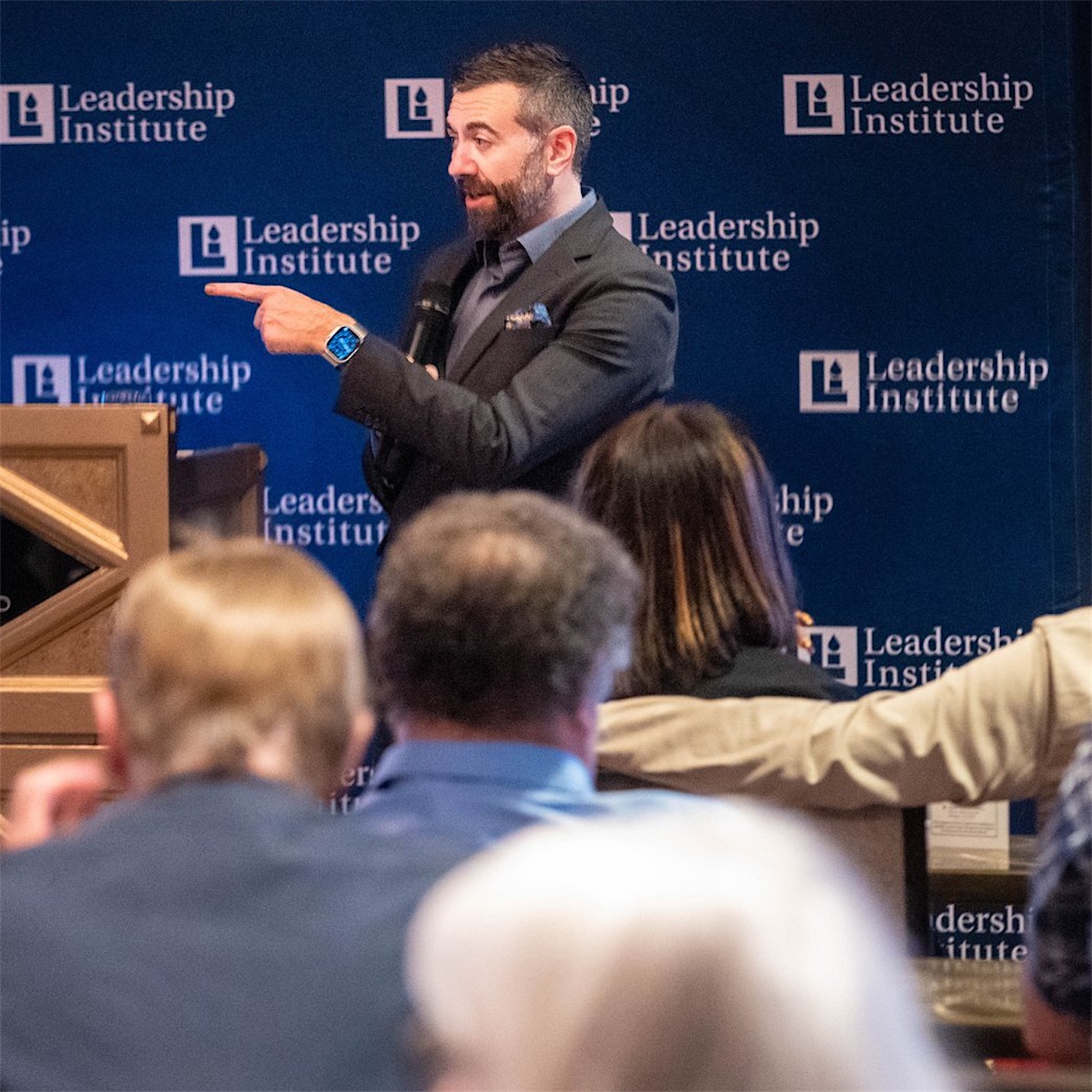 Matt Shupe pointing to the audience mid-talk in front of a Leadership Institute backdrop